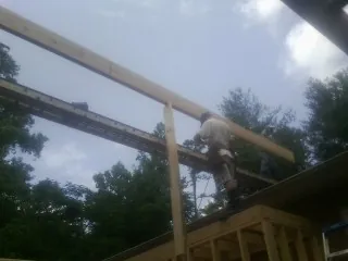 Carpenter setting a ridge beam over a new addition frame — Ice Dam Removal by Roofing Brothers in Dutton